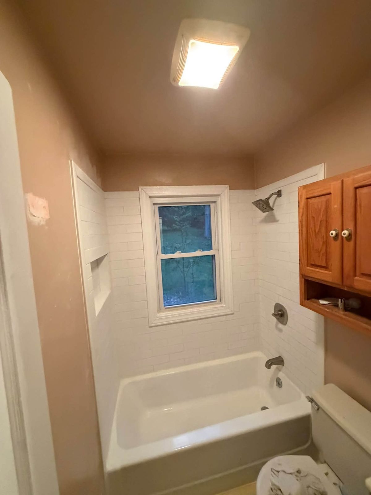 Bathroom tub surround retiled in white with a new tub installed