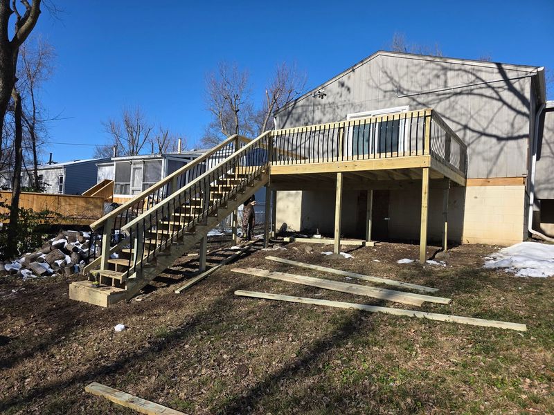 Elevated wood deck with a long stair run under construction
