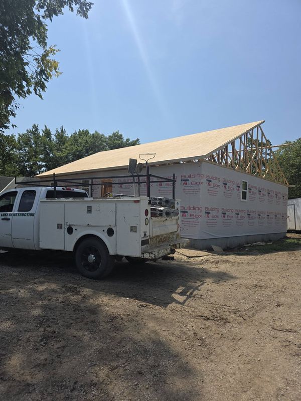 Roof decking over the trusses of the new home, house wrap up on the walls