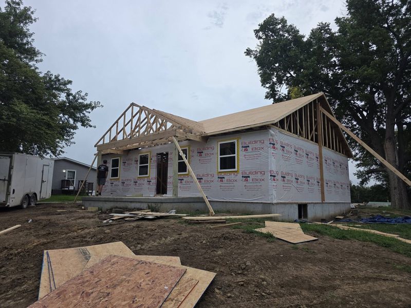 Roof trusses set and house wrap on the walls during framing