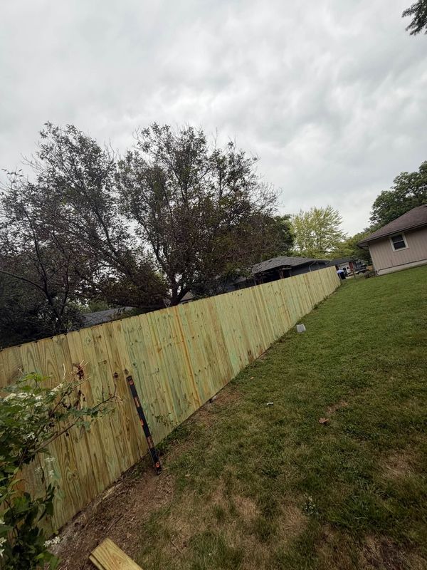 Long new wood privacy fence running down a side yard
